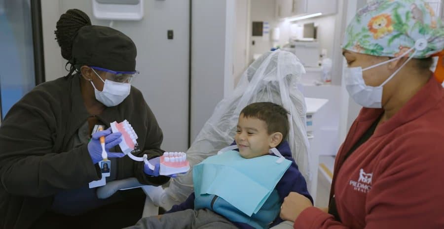 A dental clinician treating a child inside a mobile unit