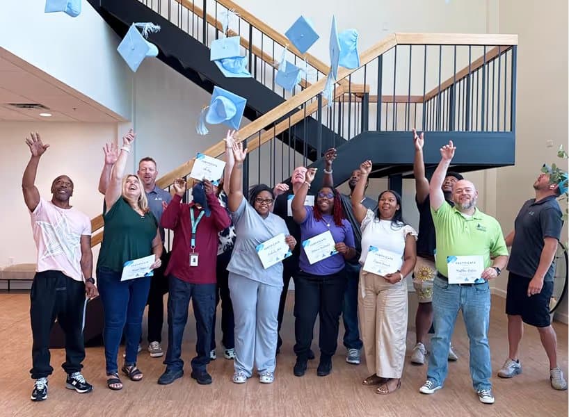 Operator training graduates celebrating with their certificates